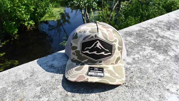 Camo branded trucker hat with genuine leather patch